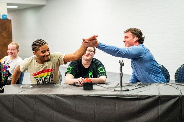  Two college students high-five during a quiz bowl challenge. 